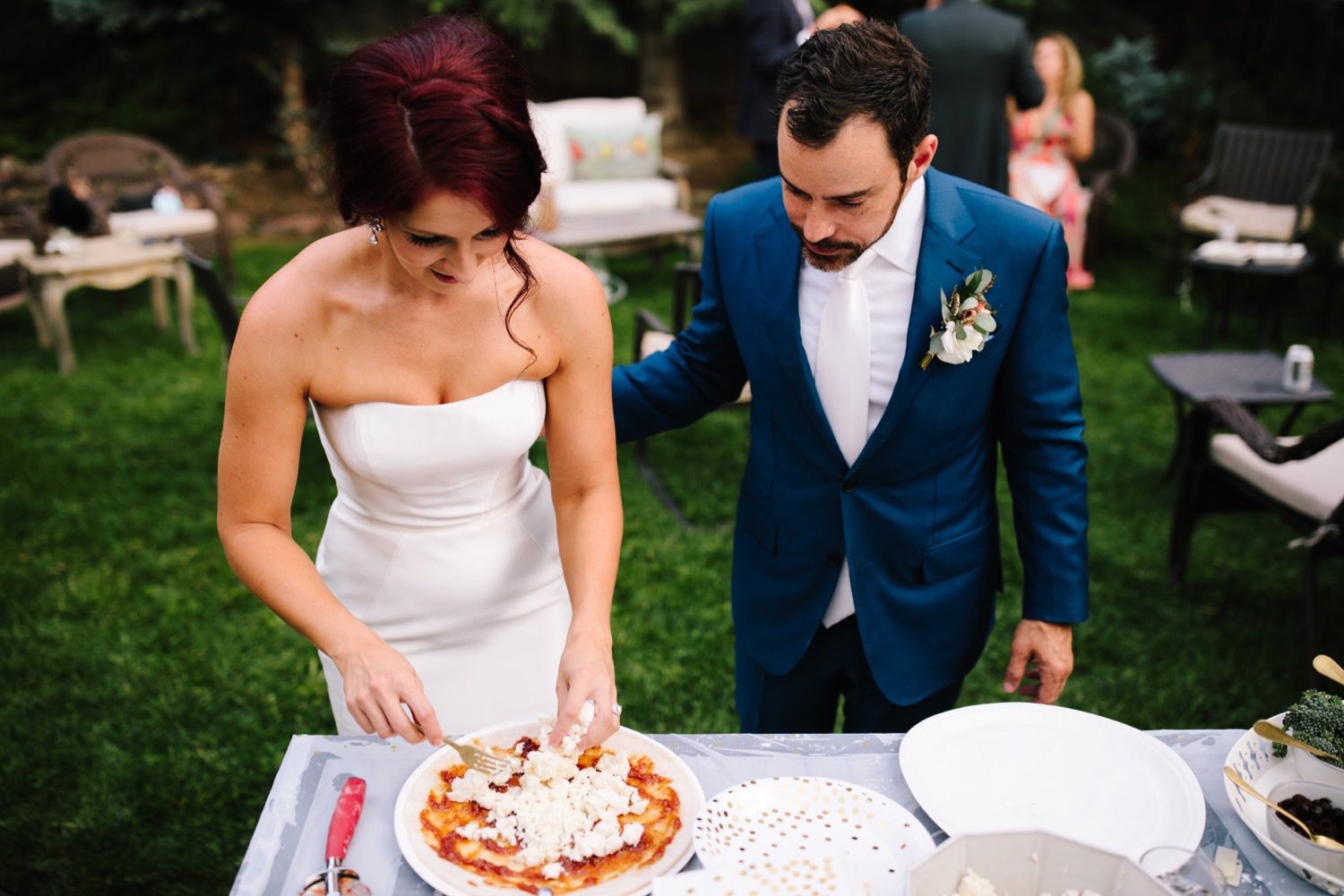 bride and groom making pizza at backyard wedding