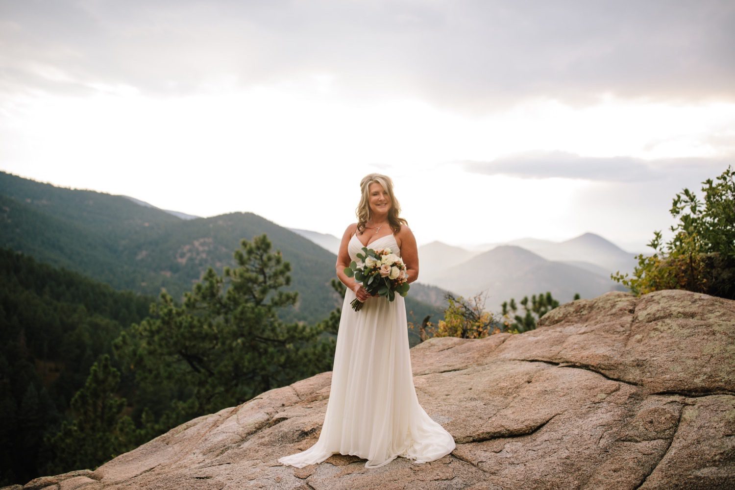 Bride holding wedding bouquet with Rocky Mountain View
