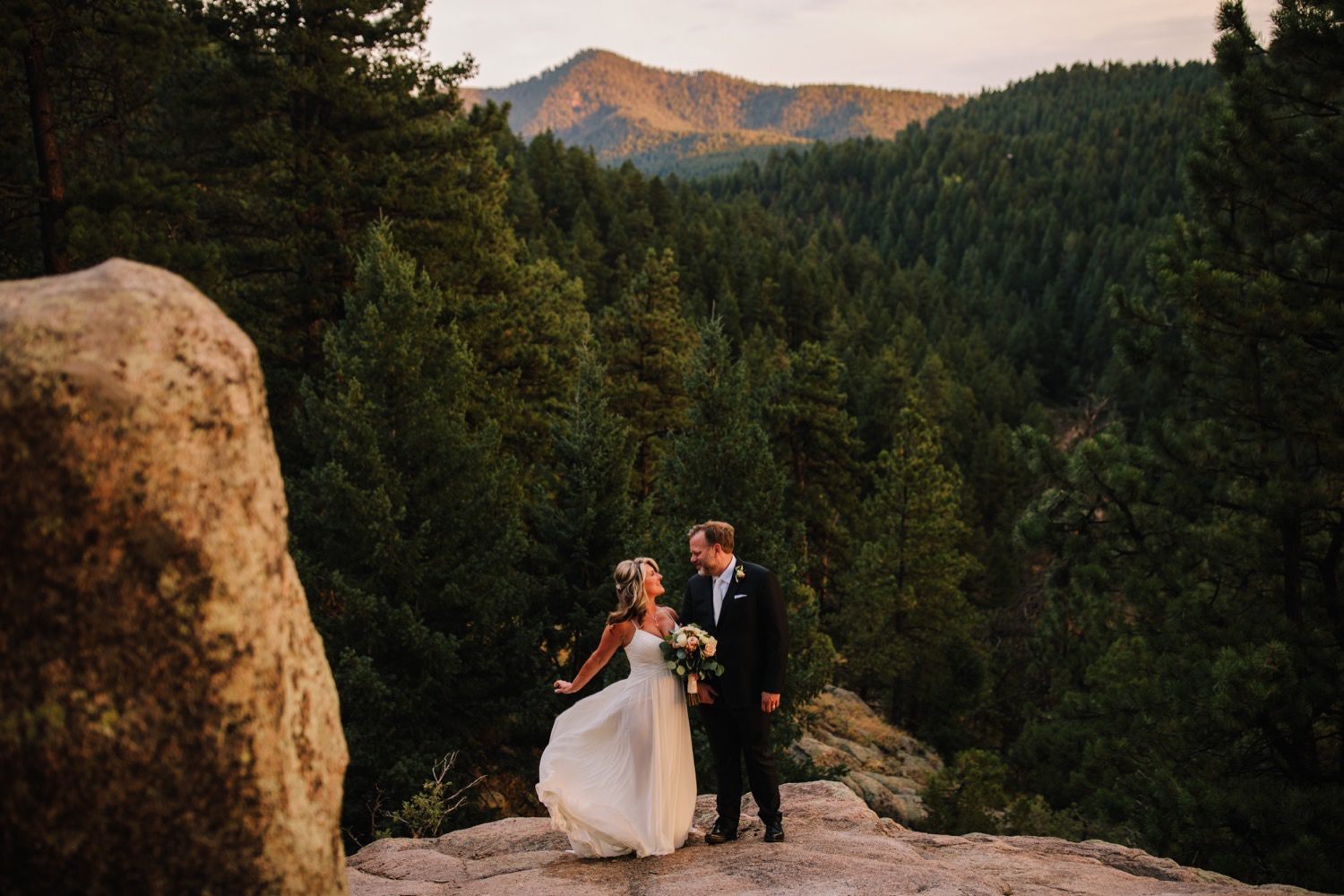 Bride and groom with pine trees and rocky mountain view