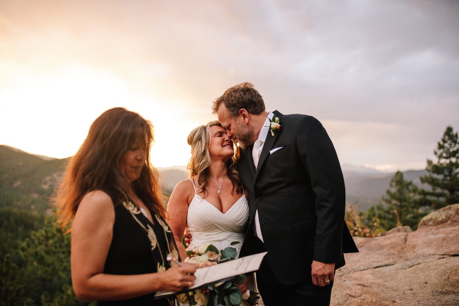 Bride groom and officiant signing marriage license for Colorado mountain elopement