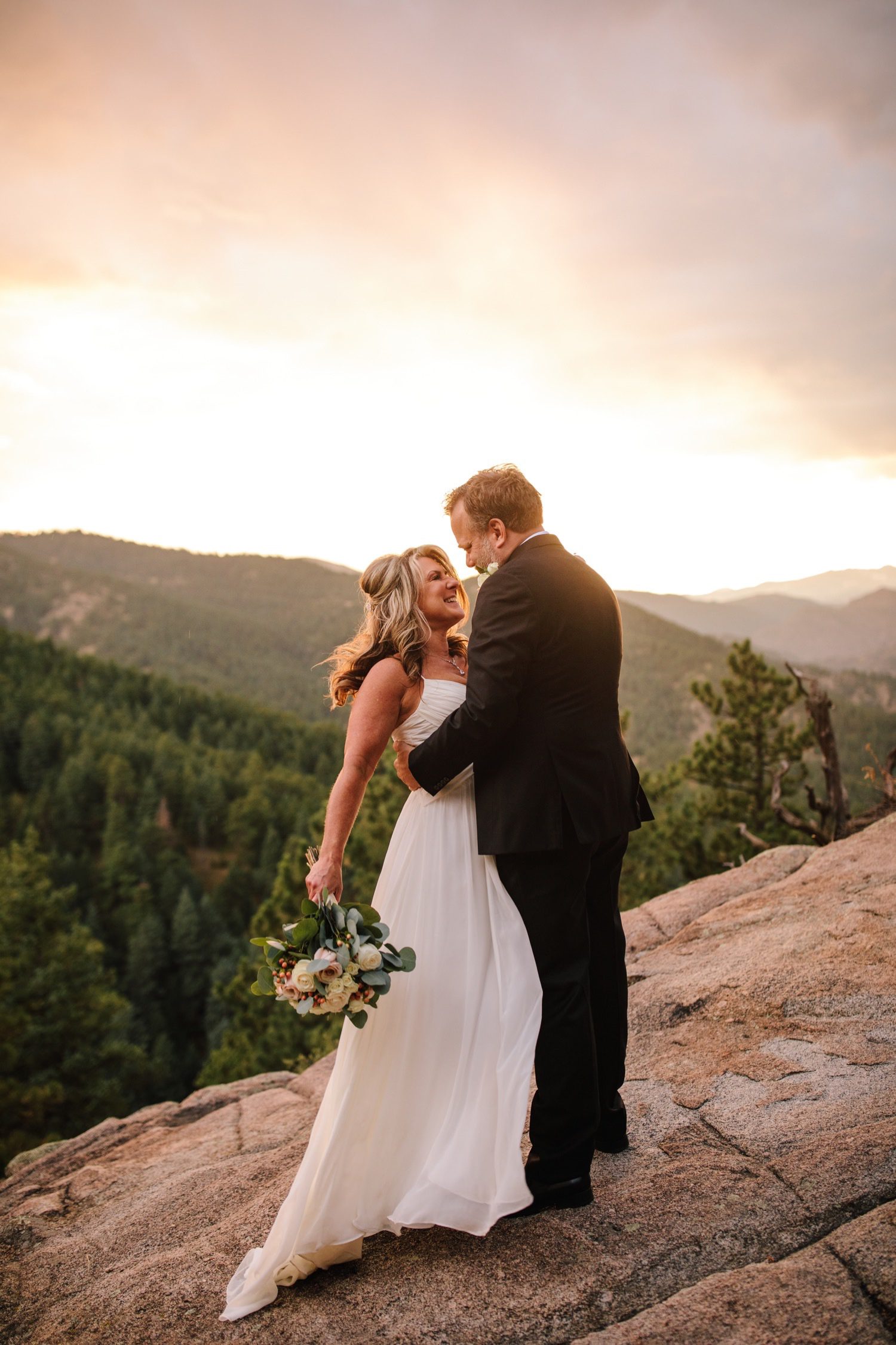 Bride and groom looking at each other with Colorado Mountain background