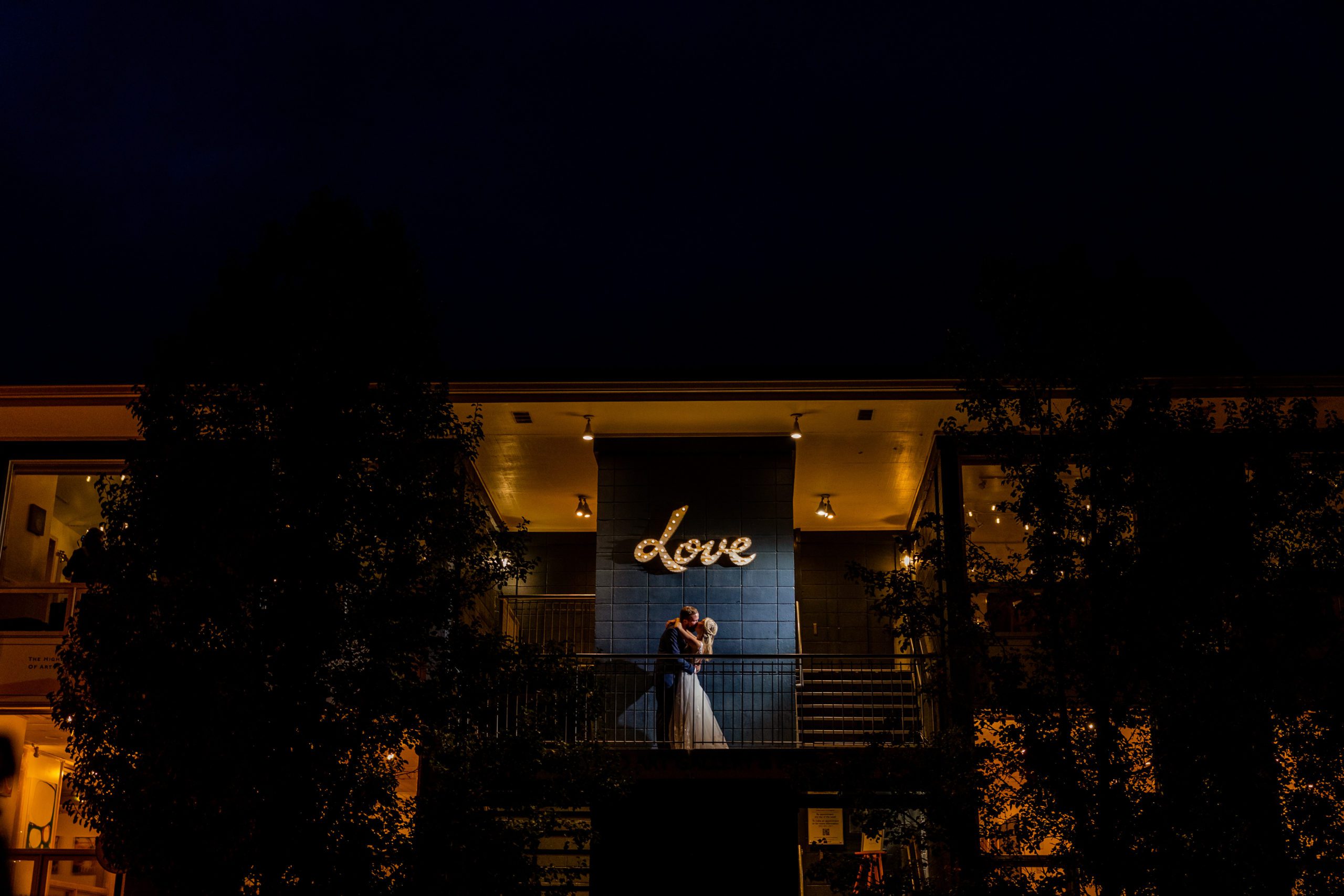 Bride and groom night portrait with love marquee sign at Rembrandt Yard in Boulder Colorado