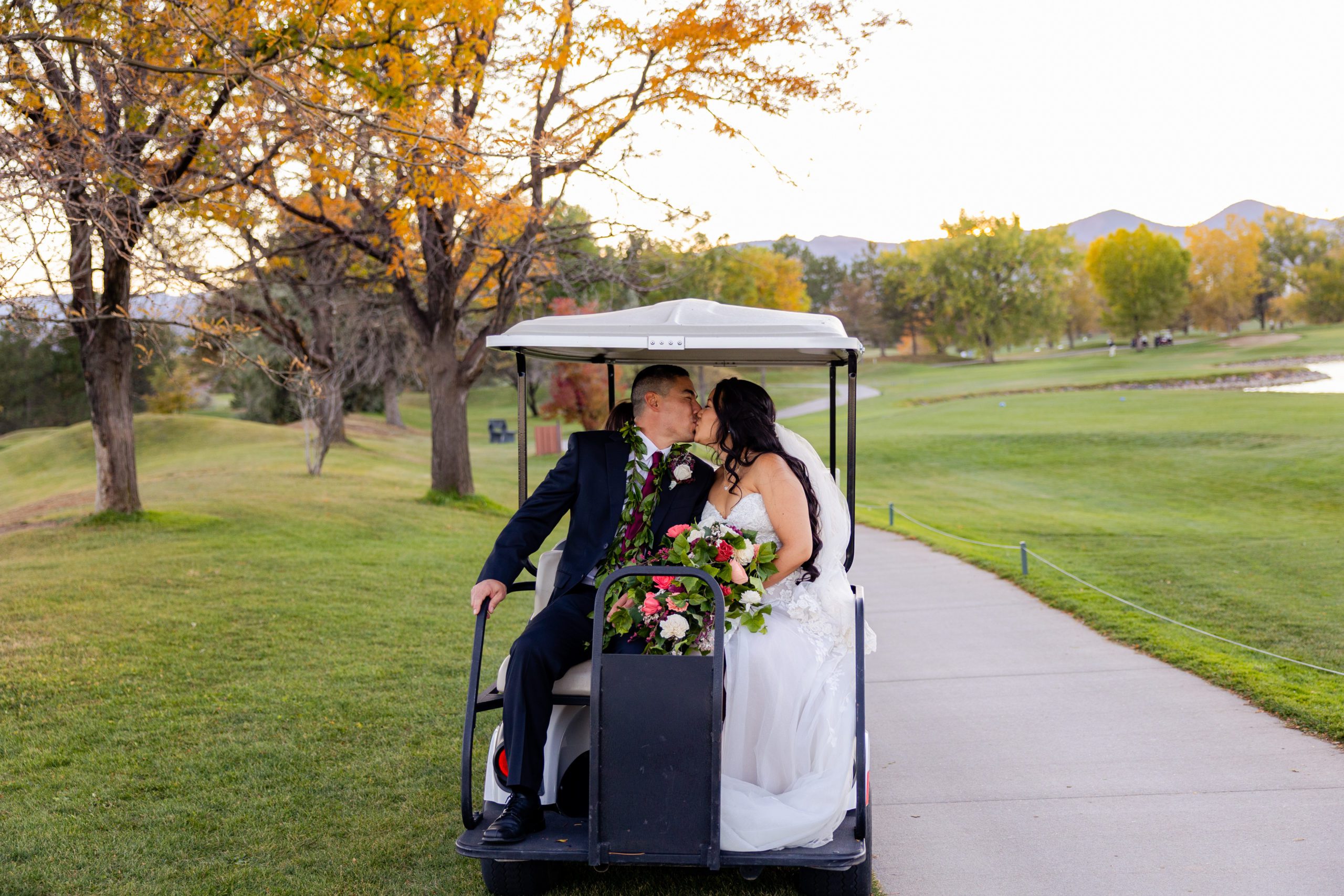 The Barn at Raccoon Creek Golf Cart kiss with bride and groom