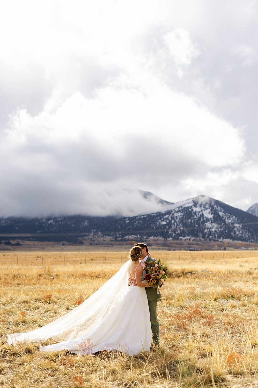Wedding photography at The Barn at Sunset Ranch in Buena Vista Colorado, Bride with long veil, Green groom suit, Mountain wedding inspiration, Boho wedding bouquet, Bridal updo