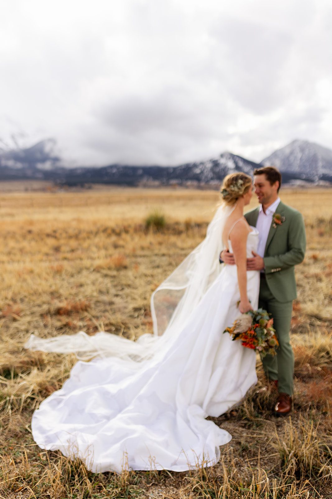 Wedding photography at The Barn at Sunset Ranch in Buena Vista Colorado, Bride with long veil, Green groom suit, Mountain wedding inspiration, Boho wedding bouquet, Bridal updo